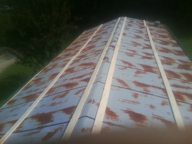 Rusted metal roof panels with new wood purlins before replacement — Storm Damage Roof Repair in Deep River by Roofing Brothers