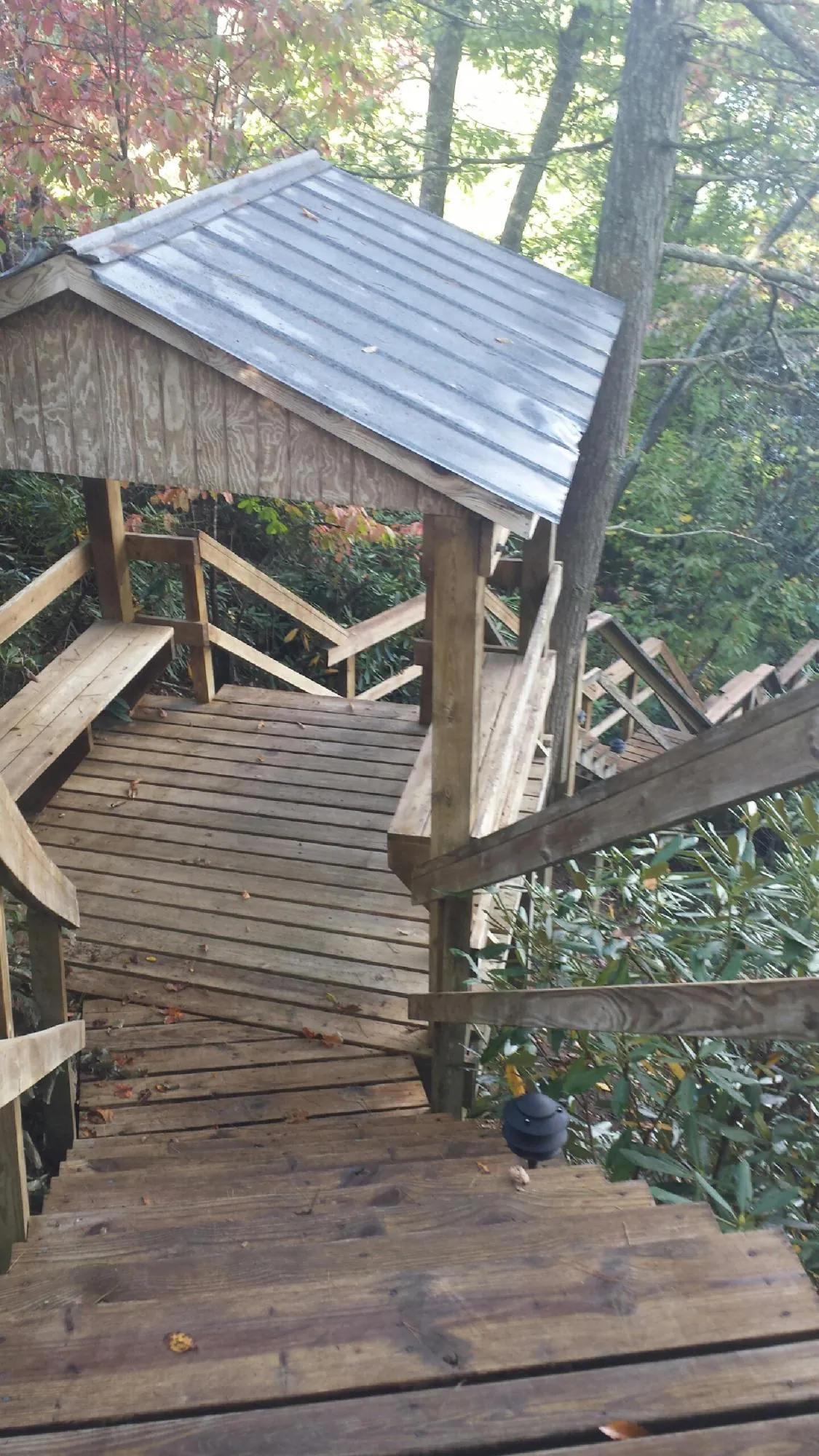 Metal roofed shelter over wooden steps on a wooded walkway — Skylight Repair & Installation work by our crew in Deep River