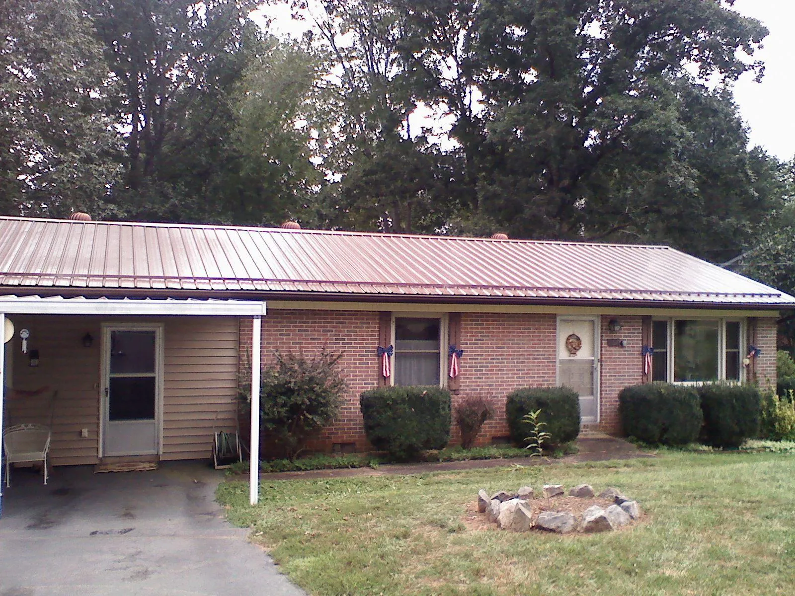 Bronze metal roof and carport on a brick ranch home — Roof Repair work by our crew in Deep River